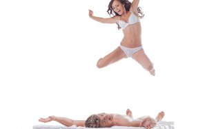 Playful Couple: Woman Jumping into Bed with Sexy Guy