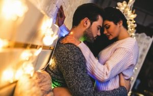 Glowing Moments: Couple Snuggled in Bed with Lights