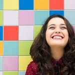 Happy Girl Laughing Against Colorful Tiles: Joyful Moment